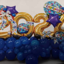 Gold 2024 balloons with blue and purple congratulatory balloons and a blue balloon base