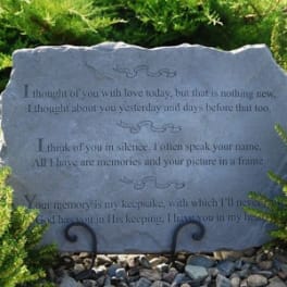 Engraved memorial stone with a sympathy poem in a garden setting