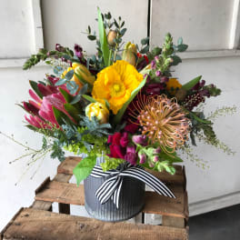 Colorful mixed bouquet in a striped ribbon-tied metal container
