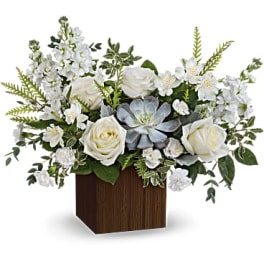 White roses and mixed white flowers in a wooden cube vase