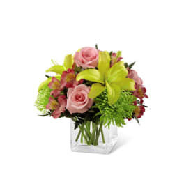 Pink roses and lime lilies in a clear square vase