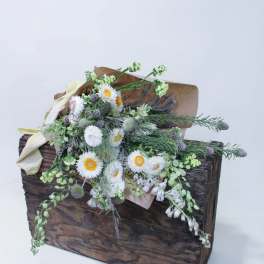 Rustic floral arrangement in a wooden box with white blooms and greenery