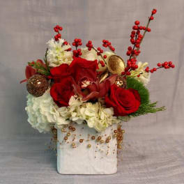 Red roses and white flowers in a white vase with gold ornaments