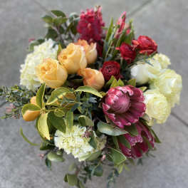 Bouquet of yellow, white, and pink flowers with greenery