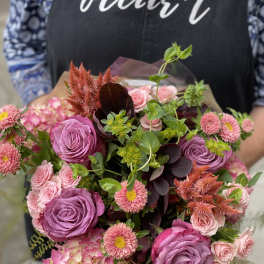 Bouquet of pink and purple roses with hydrangea and small daisy-like flowers