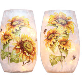 Pair of sunflower-decorated glass candle holders glowing softly