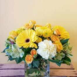 Yellow and white mixed bouquet in a square glass vase