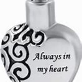 Heart-shaped silver pendant with black swirl design and text