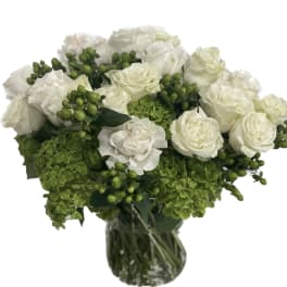 White roses and green hydrangeas in a glass vase