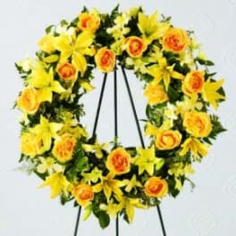 Yellow and orange floral wreath on a black stand