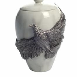 White ceramic urn with a sculpted bird decoration