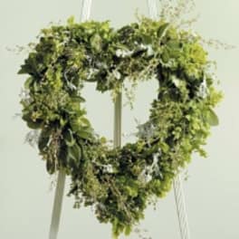 Heart-shaped greenery wreath on a hanging stand