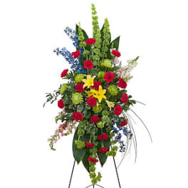 Tall standing floral spray with red, yellow, blue, and green flowers