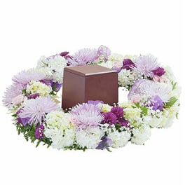 Lavender and white floral wreath around a brown urn