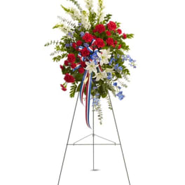 Standing floral spray with red, white, and blue flowers on an easel