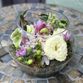 Low glass bowl arrangement with white and pink flowers nestled in moss.
