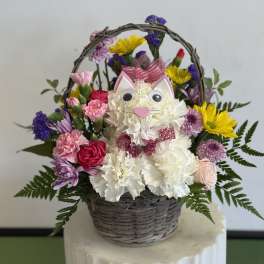 Basket arrangement with a cat face made of white flowers and colorful blooms