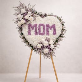 Heart-shaped floral easel tribute with "MOM" in purple flowers
