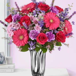 Bouquet of pink and red flowers in a clear glass vase