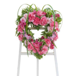 Pink carnation wreath on a white easel