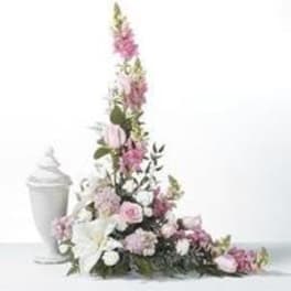 Tall pink and white floral arrangement with a white urn