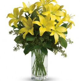 Yellow lilies arranged in a clear glass vase