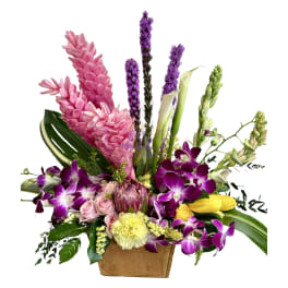 Mixed bouquet with purple orchids, pink flowers, and yellow tulips in a wooden box