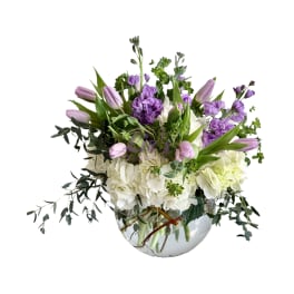 Purple tulips and white hydrangeas in a clear glass vase