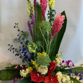 Tall tropical arrangement with pink ginger, red anthuriums, and purple orchids