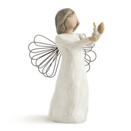 Angel figurine in a white dress holding a candle