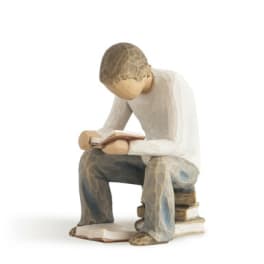 Wooden figurine of a seated person reading a book