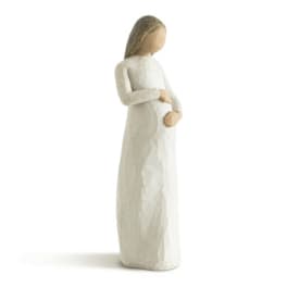 Carved figurine of a standing woman in a cream dress