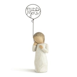 Small figurine of a girl holding a wire balloon that says "miss you"