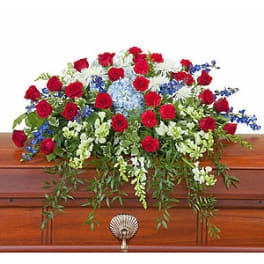 Red roses and mixed white-blue flowers arranged on a casket