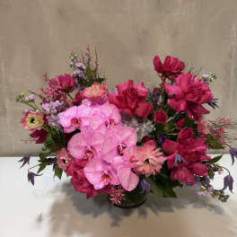 Pink and purple floral arrangement in a low vase