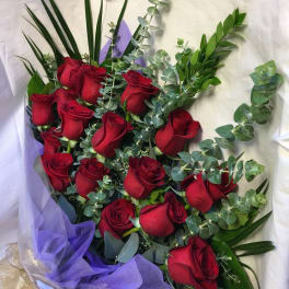 Bouquet of red roses with eucalyptus and purple wrapping