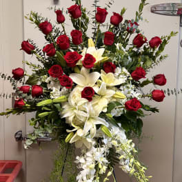Standing floral spray with red roses, white lilies, and white orchids