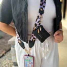 Person wearing a black-and-white lanyard with a phone case attached