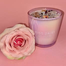 Pink rose beside a lavender glass candle with "Miss Daisy Las Vegas" text