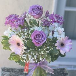 Lavender roses and pink gerbera daisies in a glass vase