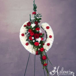 Red and white funeral wreath on a stand with roses and carnations