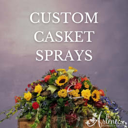 Colorful casket spray with sunflowers, roses, and mixed blooms