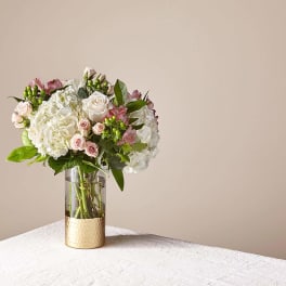 Bouquet of white and blush flowers in a glass vase