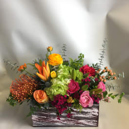 Colorful mixed flower arrangement in a rustic wooden box