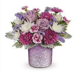 Bouquet of pink and lavender flowers in a glittery purple vase