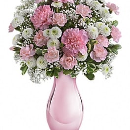 Pink and white carnation bouquet in a pink glass vase