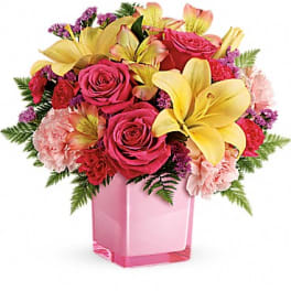 Pink roses and yellow lilies in a pink glass vase
