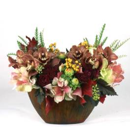 Floral arrangement in a wooden bowl with orchids and roses