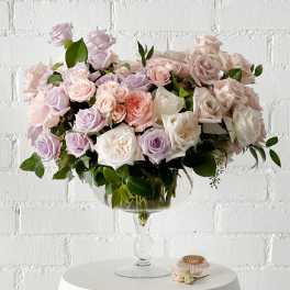 Large pastel rose arrangement in a clear glass vase