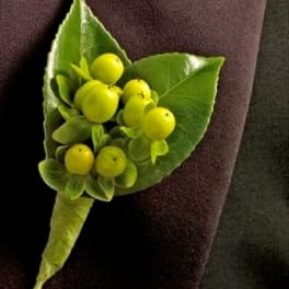 Green boutonniere with yellow berries on a dark jacket